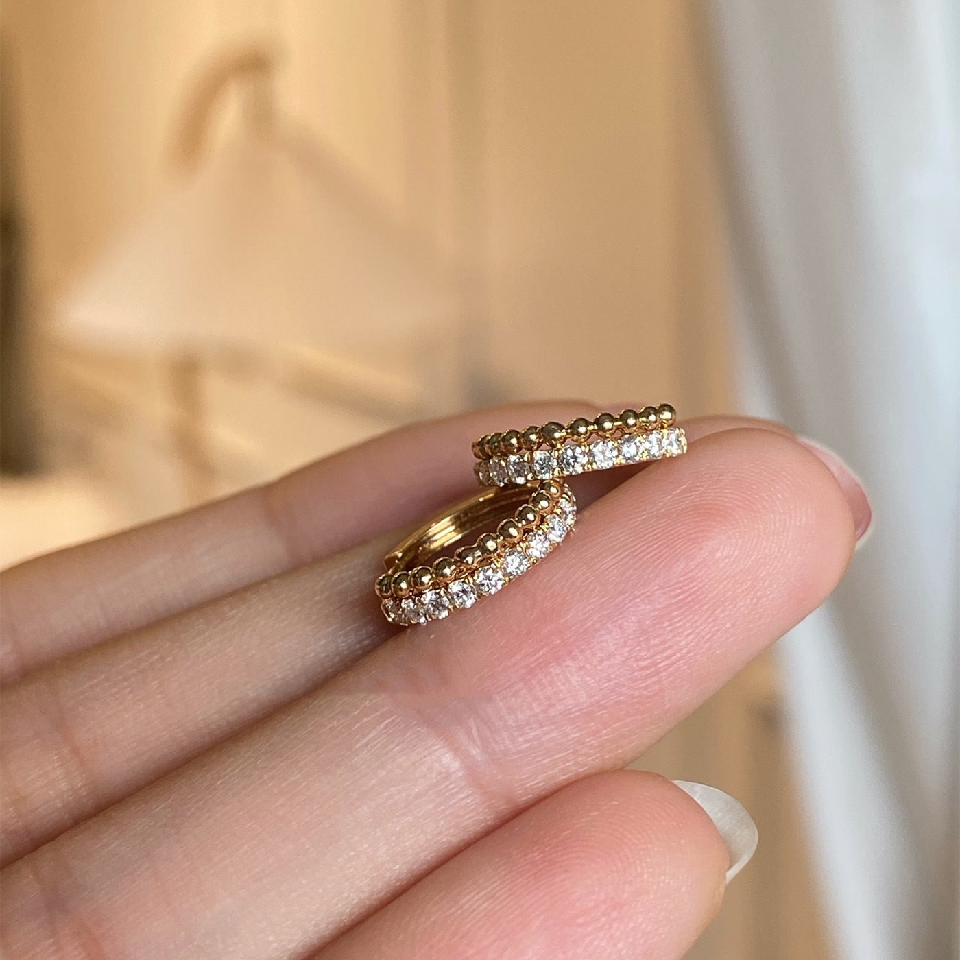 Side view of sparkling CZ beaded huggie hoop earrings in 18k gold plated 925 silver, wholesale jewelry for boutiques.