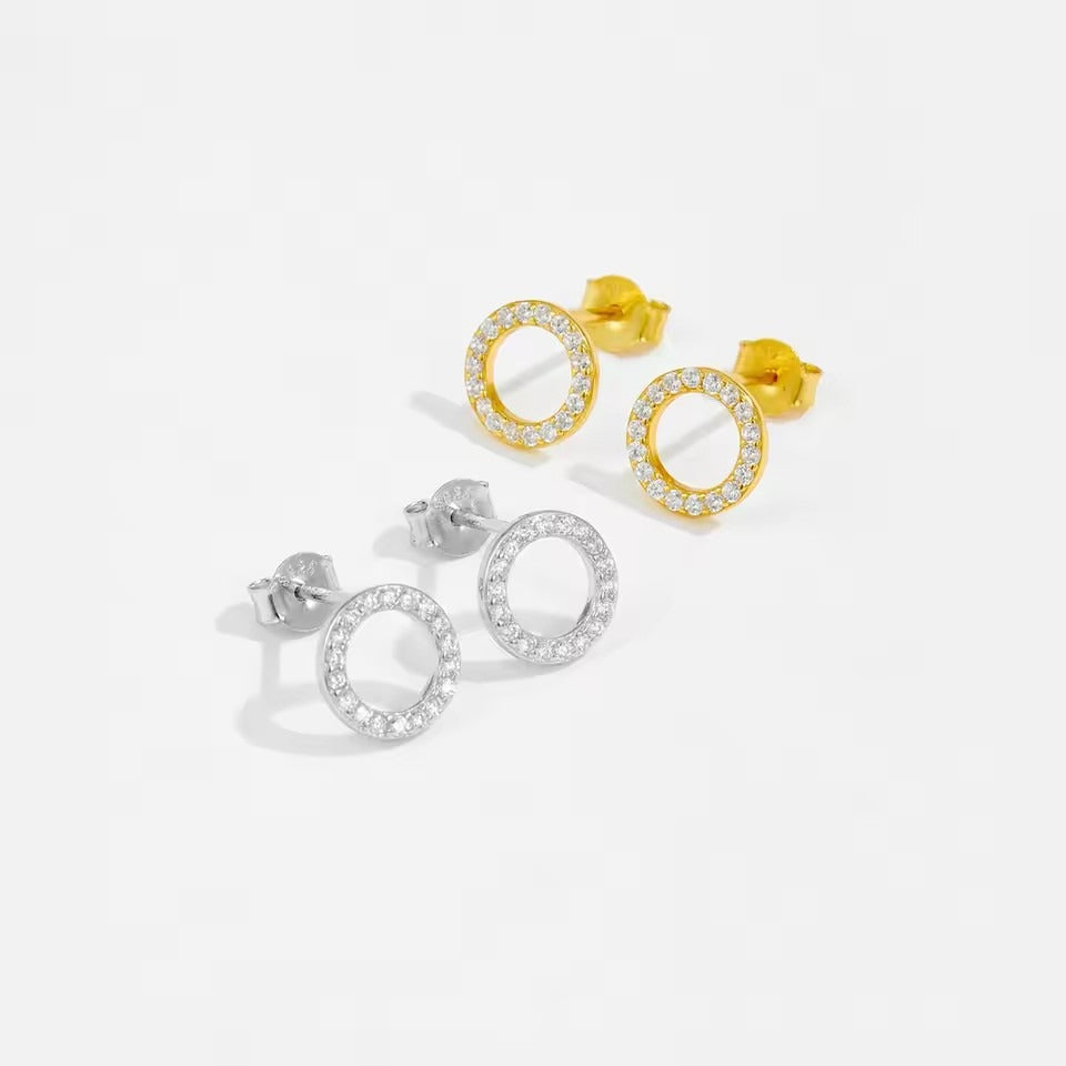 Sparkling gold round stud earrings with pavé zircon setting, shown under soft natural light on a marble background