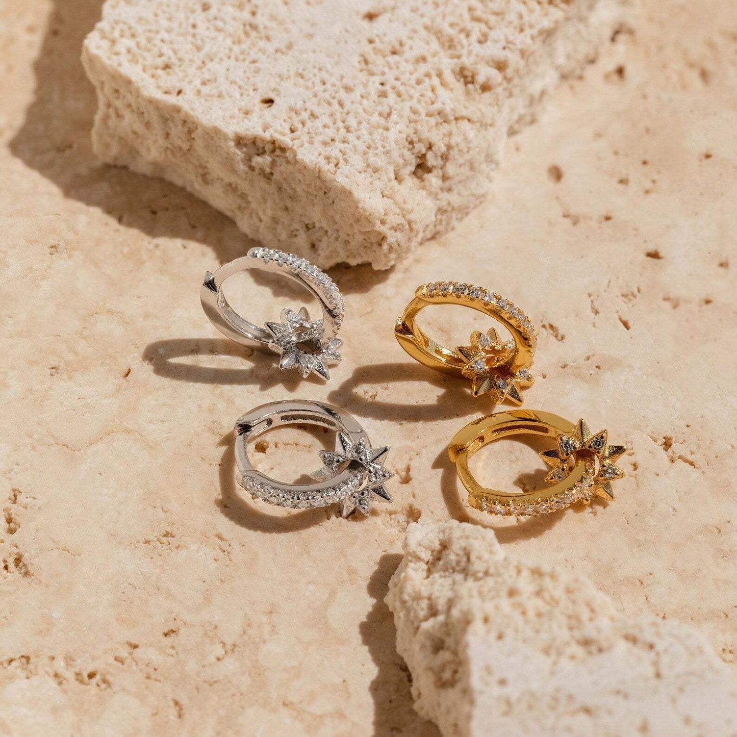 Gold-plated S925 huggie earrings with removable star charms and cubic zirconia accents, shown on a soft fabric background