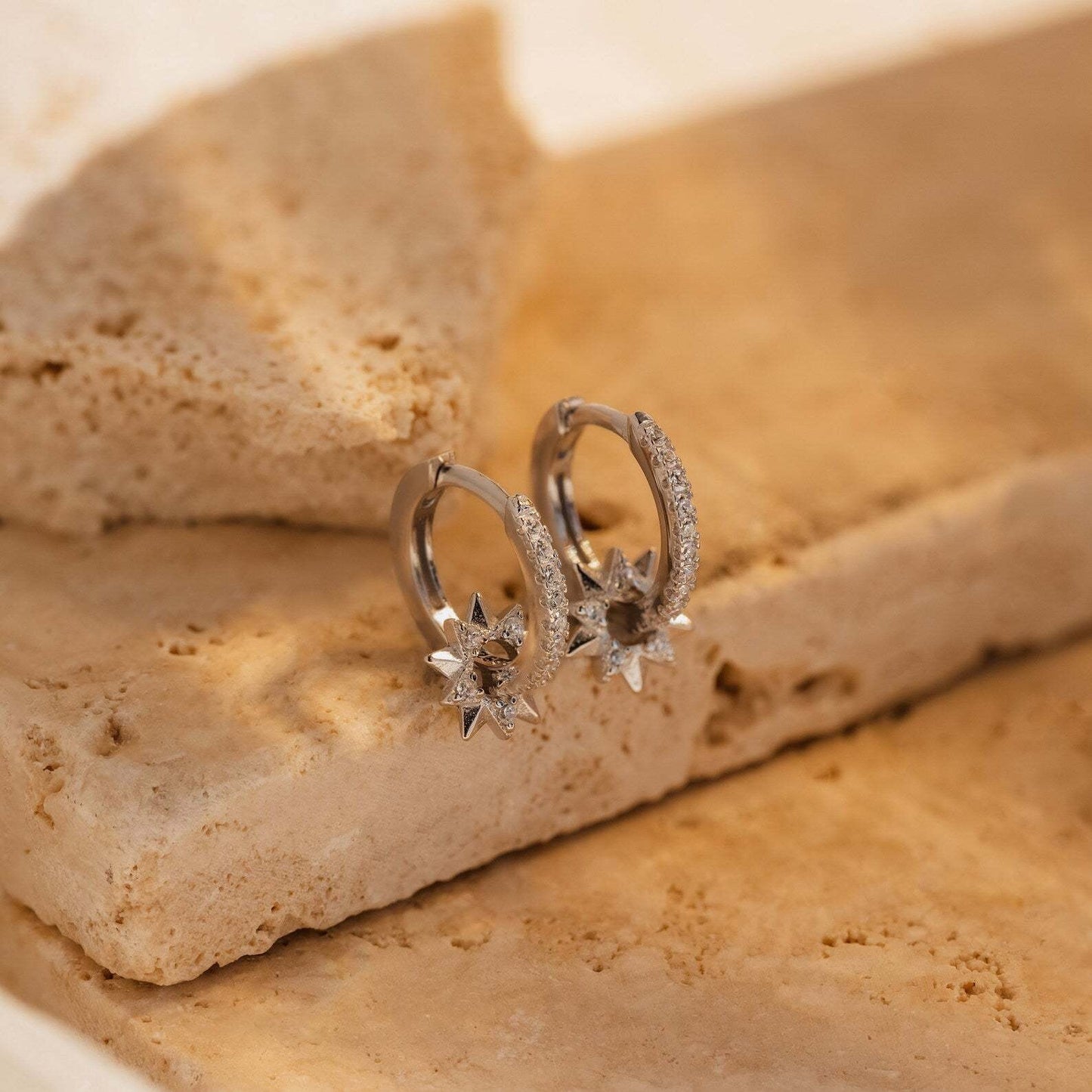 Minimalist gold star charm earrings with CZ sparkle, photographed as dainty holiday jewelry for everyday and party looks