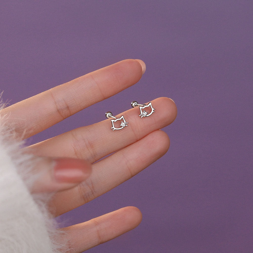 Sterling silver cat ear stud earrings with sparkling cubic zirconia, displayed on soft pink fabric for a festive gift look