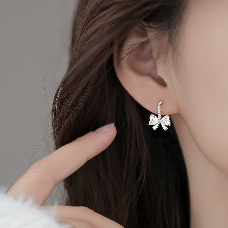 Close-up of sparkling bow-shaped earrings made of sterling silver and CZ, perfect for Valentine’s Day or bridal gifts