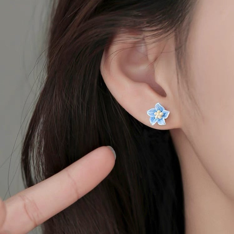 s925 blue flower stud earrings with delicate petals, photographed in soft natural lighting
