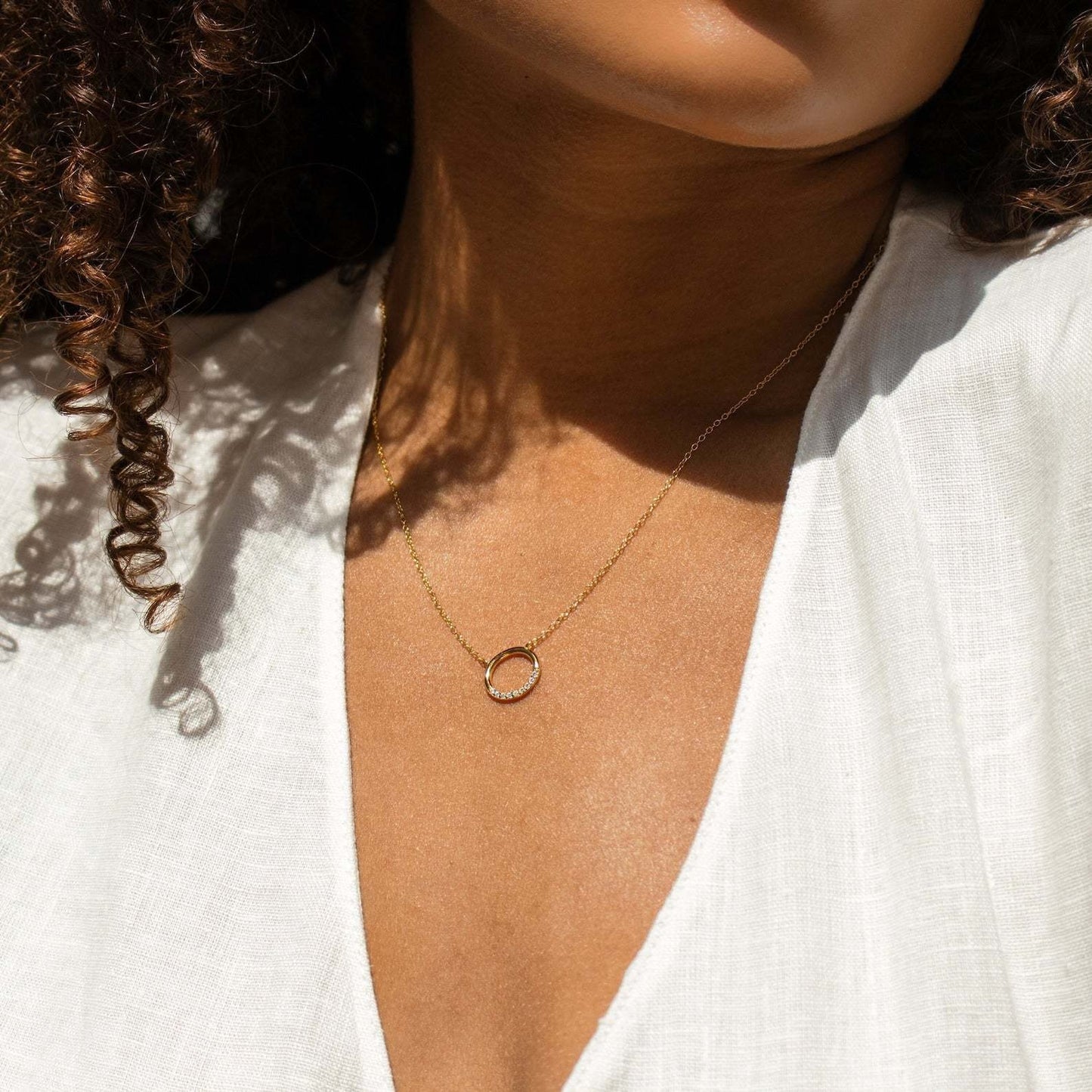 Simple cubic zirconia circle necklace displayed on minimal jewelry tray