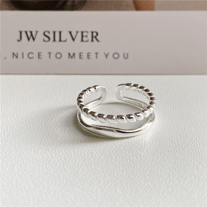 minimalist silver bridesmaid ring with open adjustable band on white background