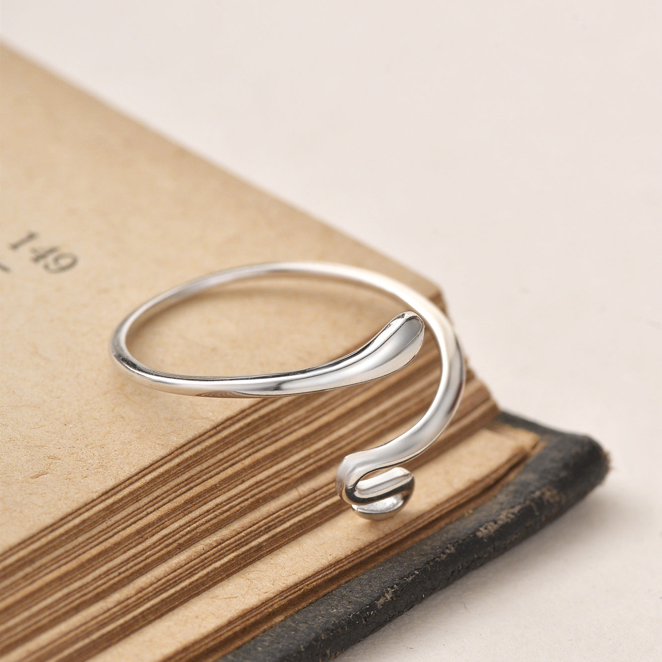 close-up of silver snake open ring with smooth polished finish and curved tips