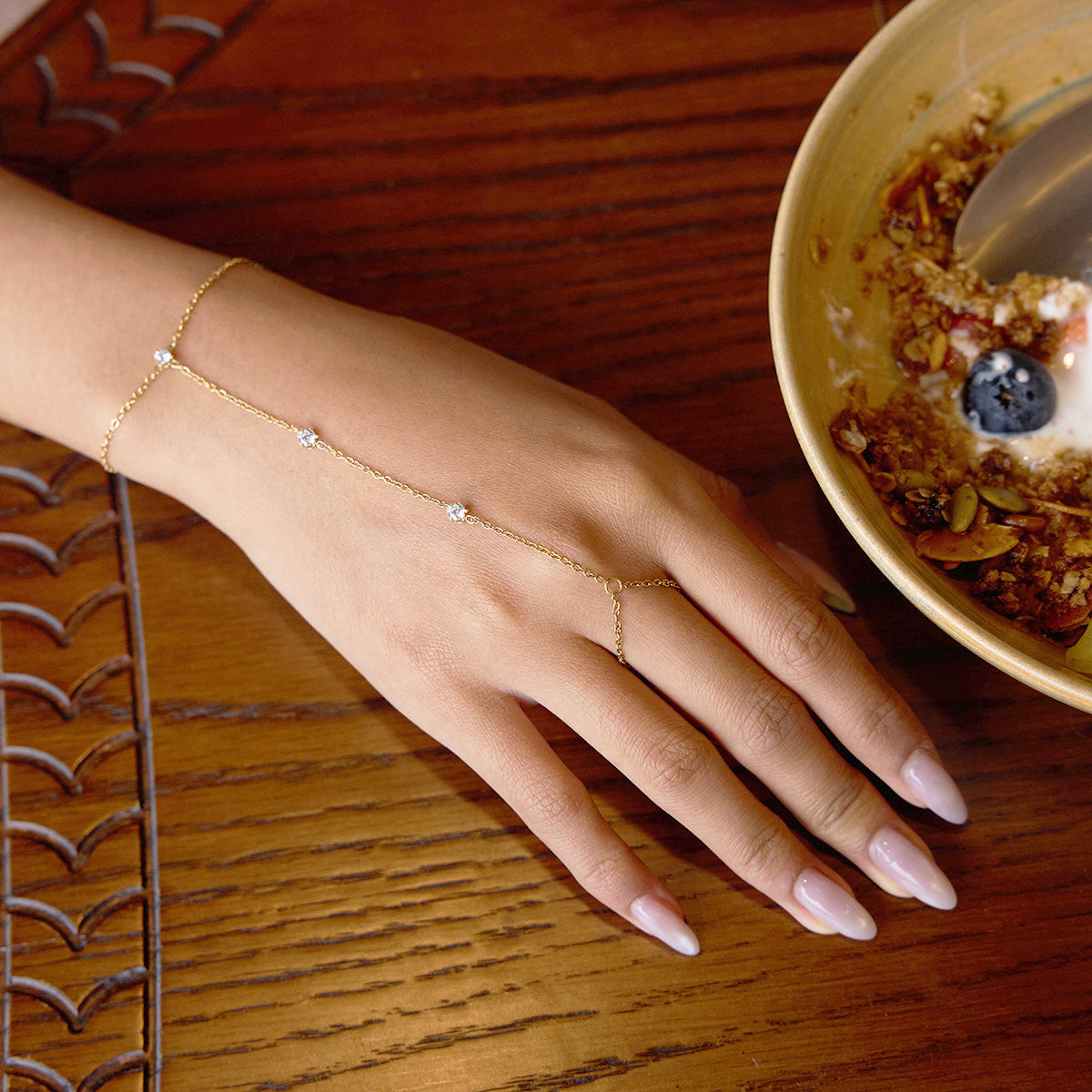 Close-up of a minimalist finger bracelet for women made from Gold Plated Stainless Steel with Cubic Zirconia stones, ideal as a hand chain bracelet gift idea.