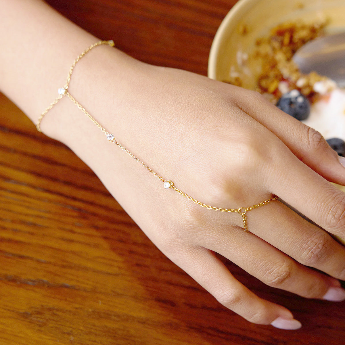 legant Gold Plated Hand Chain Bracelet laid flat showcasing Cubic Zirconia detailing, a lightweight and hypoallergenic finger bracelet for women.