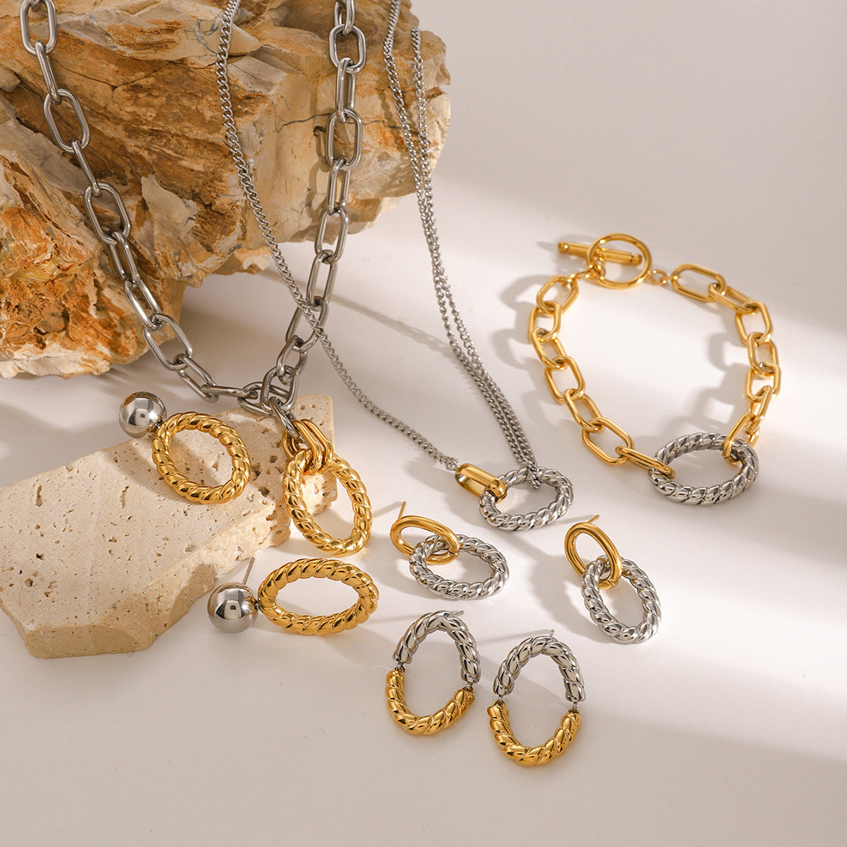 Complete jewelry set featuring two tone oval twist earrings, bracelet, and necklace. Ideal stainless steel jewelry set for women, showcasing chunky geometric pieces for wholesale or gifting.