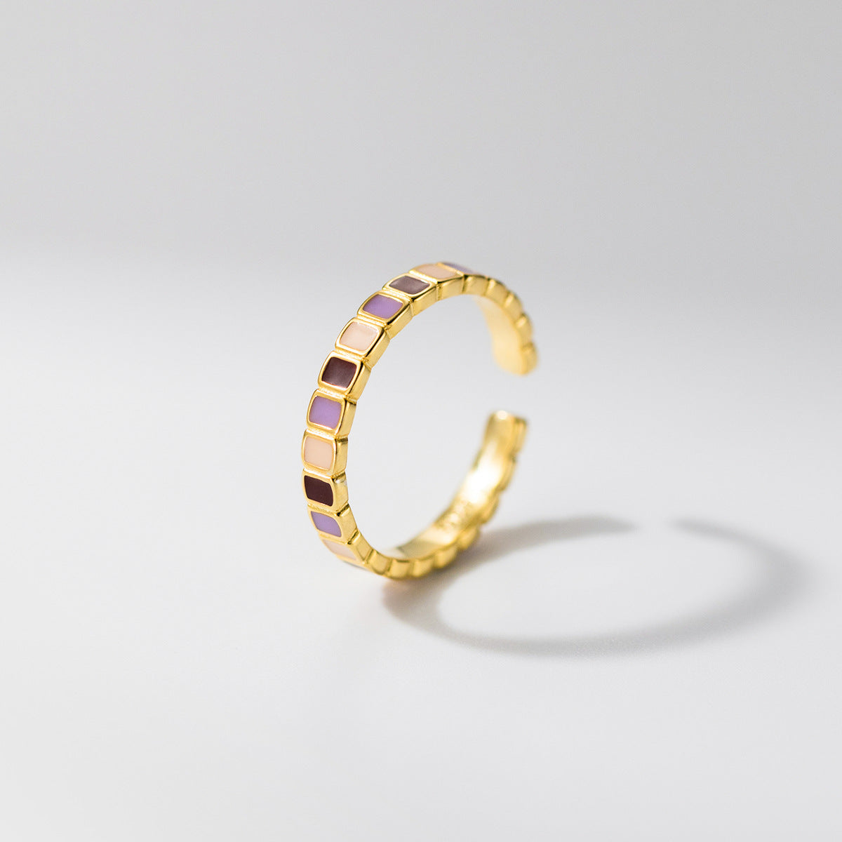 Side view of wholesale 925 sterling silver adjustable color block enamel geometric ring, gold band with purple, cream, and burgundy square patterns for fashion jewelry suppliers.