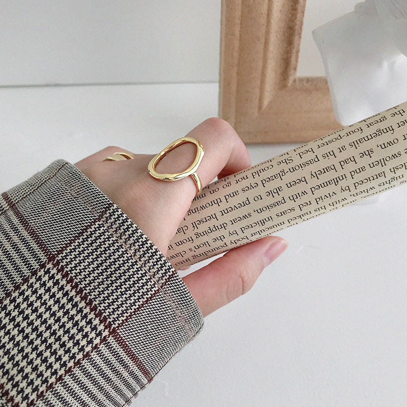 Model wearing 18k gold oval open ring on finger, showcasing minimalist everyday jewelry made of 925 silver for wholesale fashion retailers.