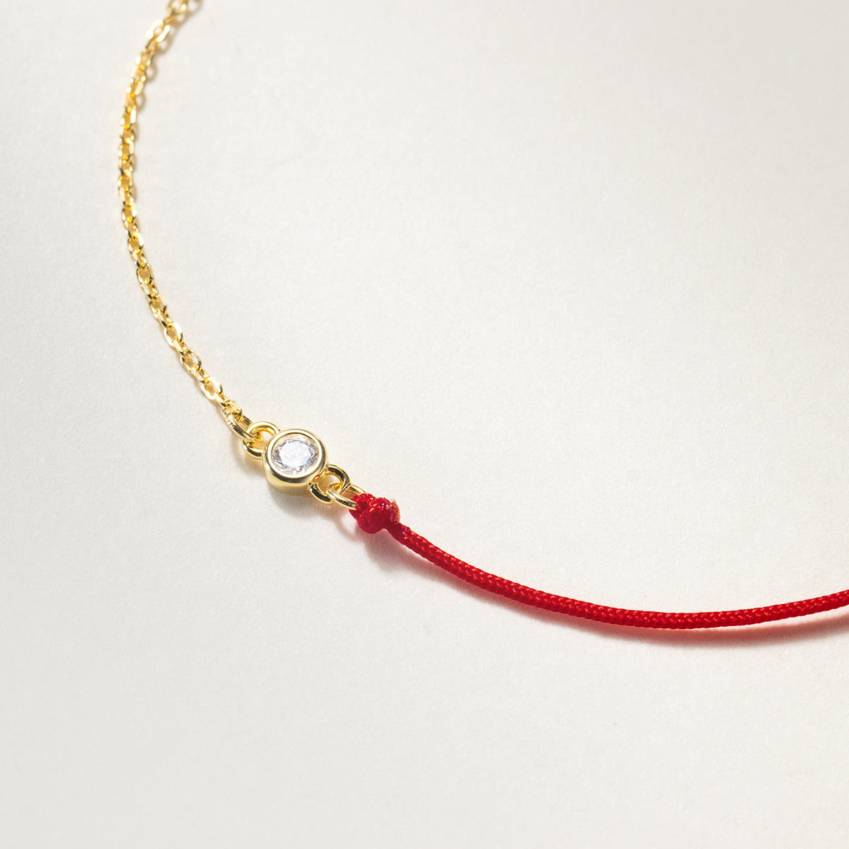 Close-up of minimalist red string cubic zirconia charm bracelet, ideal for wholesale 925 silver jewelry suppliers.