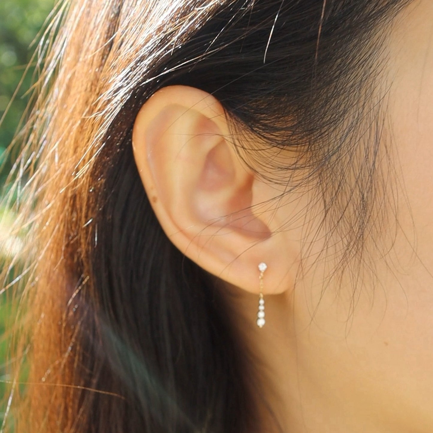 Model wearing gold CZ chain drop dangle earrings, wholesale 925 sterling silver earrings for wedding and formal events.