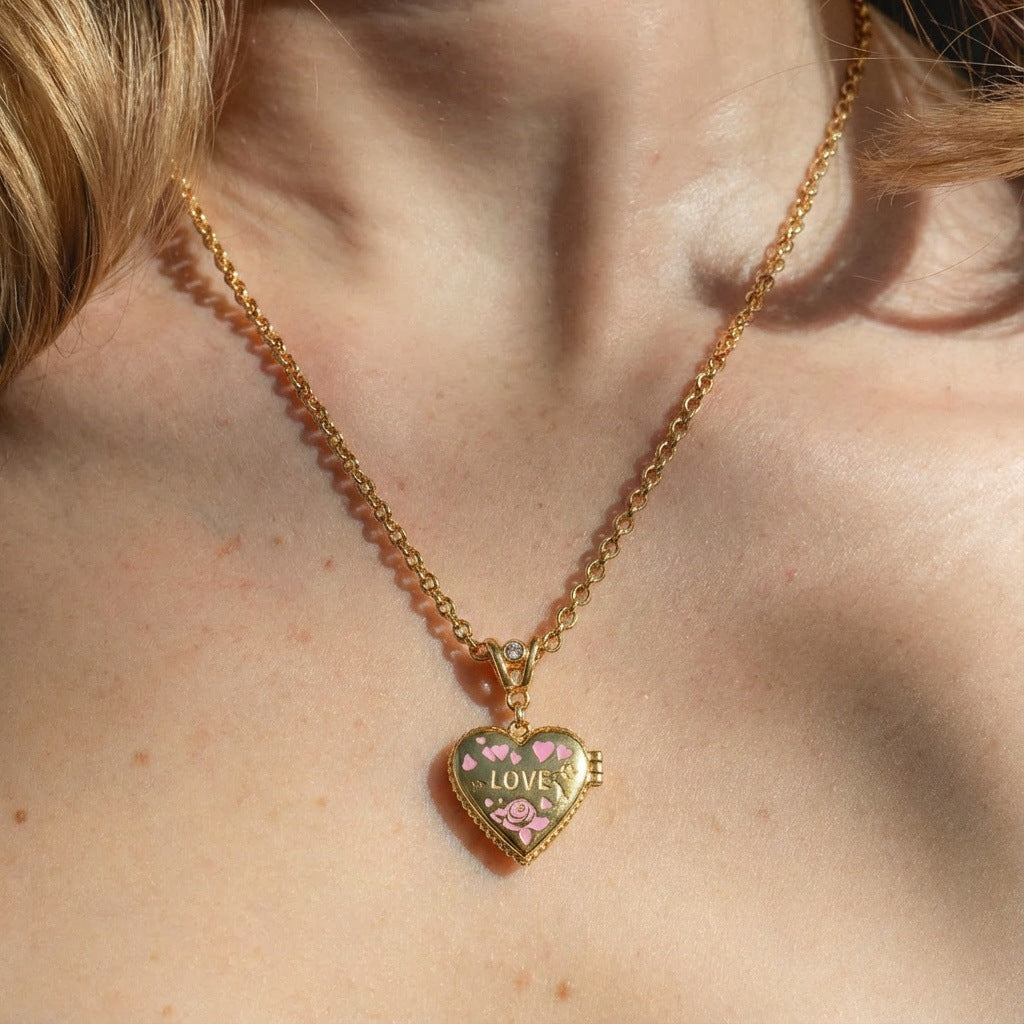 Heart locket necklace worn on model with openable photo frame pendant and pink enamel love design