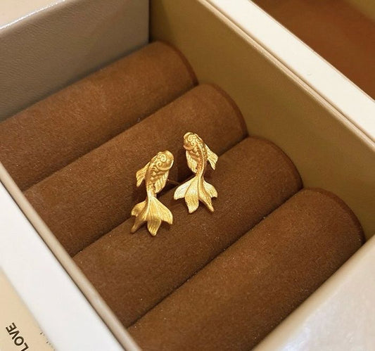 Pair of gold koi fish earrings displayed in jewelry box, brass jewelry wholesale lucky studs
