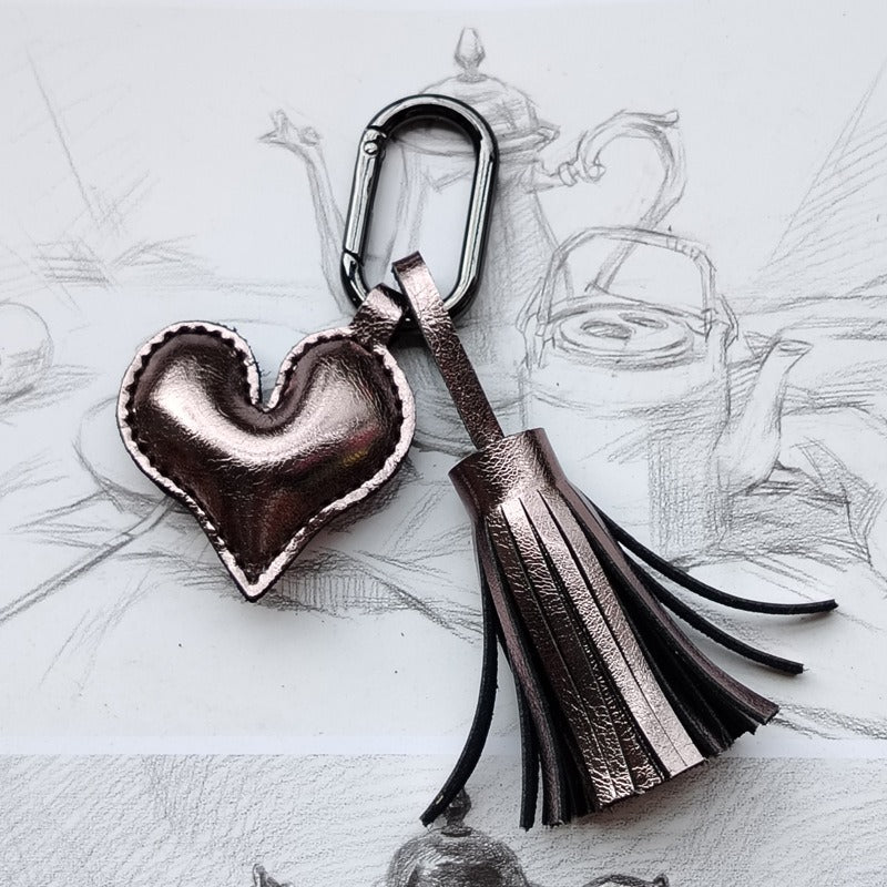 Bronze leather heart keychain with dark tassel and metal clasp for fashion bags.