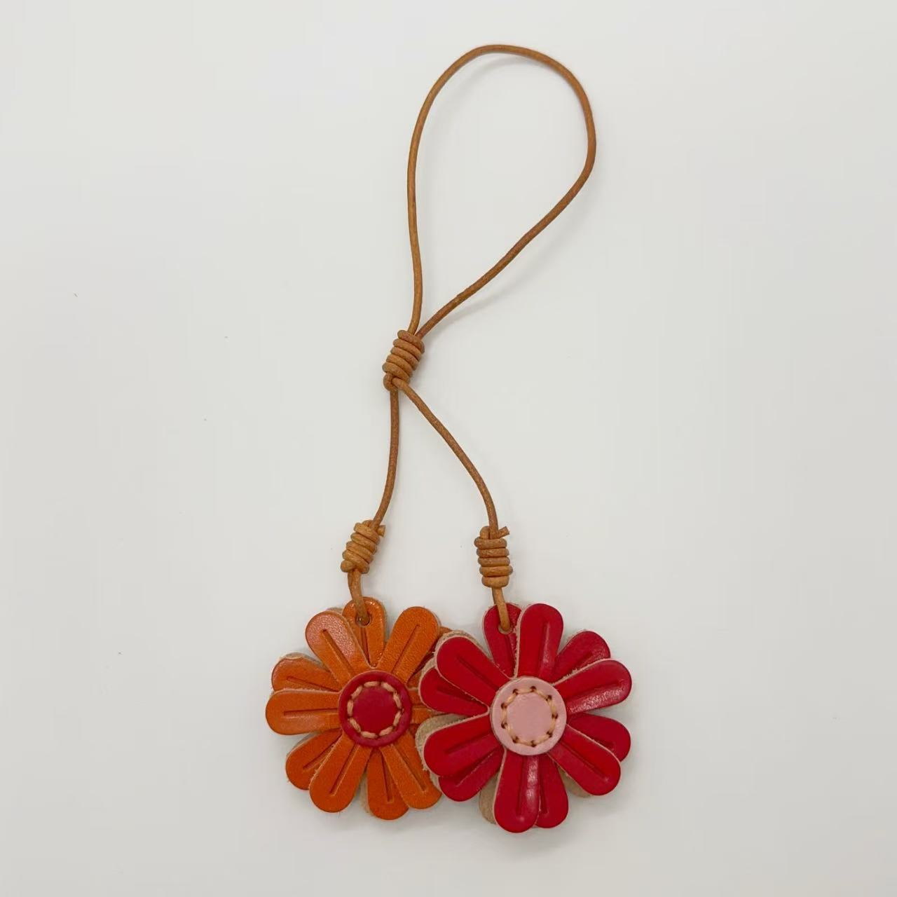Genuine leather flower keychains in orange and red, handmade daisy bag charm for creative gift idea or wholesale accessory.