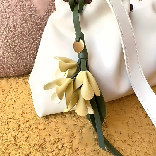 Lifestyle image of yellow PU leather flower bag charm keychain attached to white tote wholesale friendly design