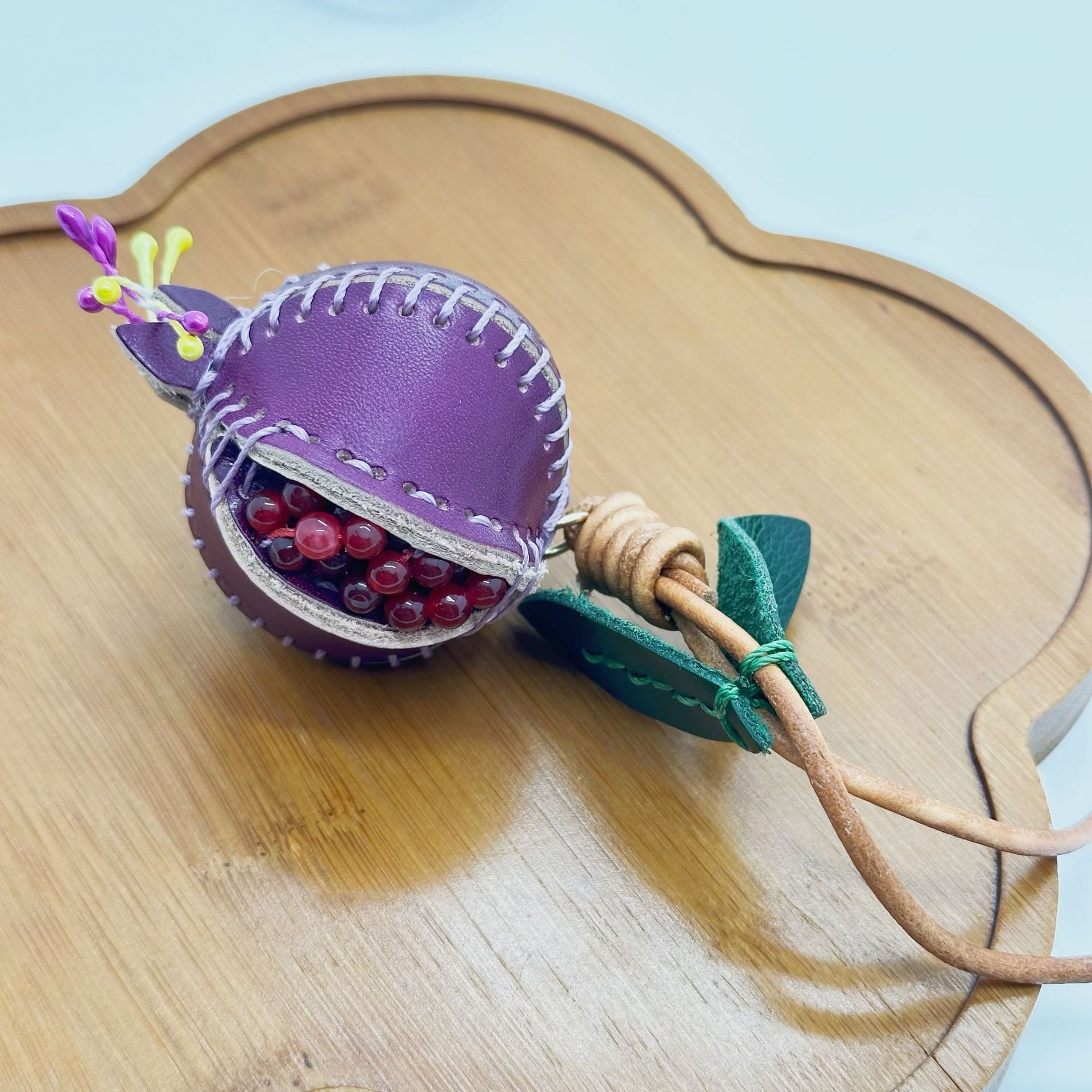Handmade pomegranate charm genuine leather bag charm for handbag decoration, featuring realistic red bead seeds and green leaves, perfect as fruit bag charm or car rearview mirror charm for bag charm wholesale and fashion accessories wholesale collections.