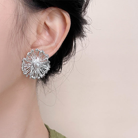 Model wearing statement floral earrings with pearl center, trendy brass jewelry wholesale