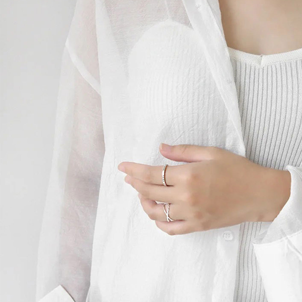 Model wearing minimalist sterling silver crossover rings in a stylish white outfit - perfect for minimalist jewelry wholesale and fashion boutiques