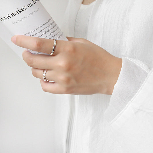 Close-up of sterling silver open crossover ring on hand holding a paper, ideal for open ring bulk sales and minimalist jewelry wholesale
