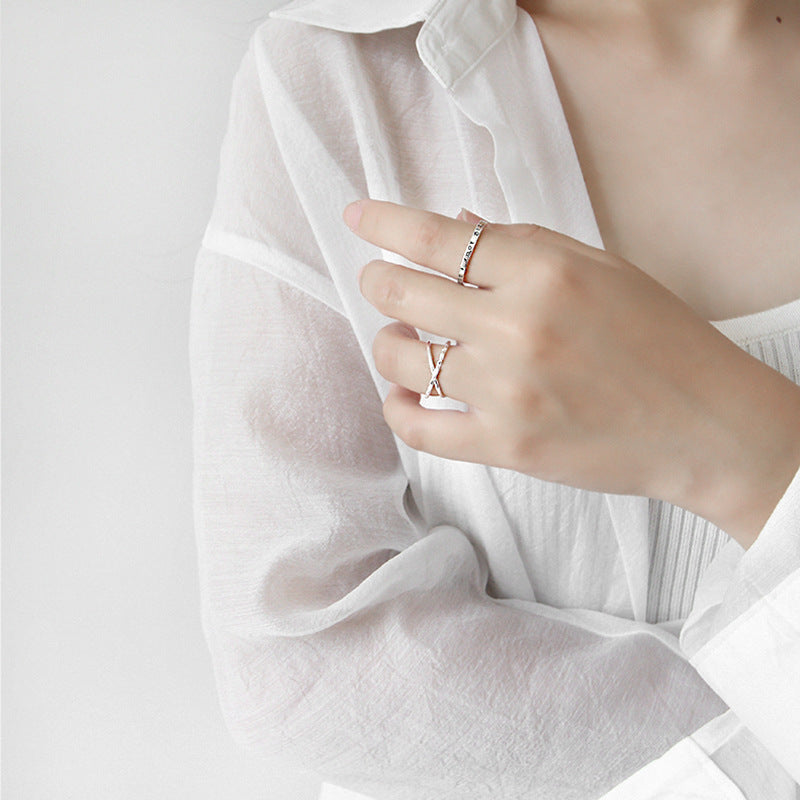 Double band sterling silver rings with crossover design worn by model in white blouse - best-selling kpop style rings for wholesale jewelry buyers