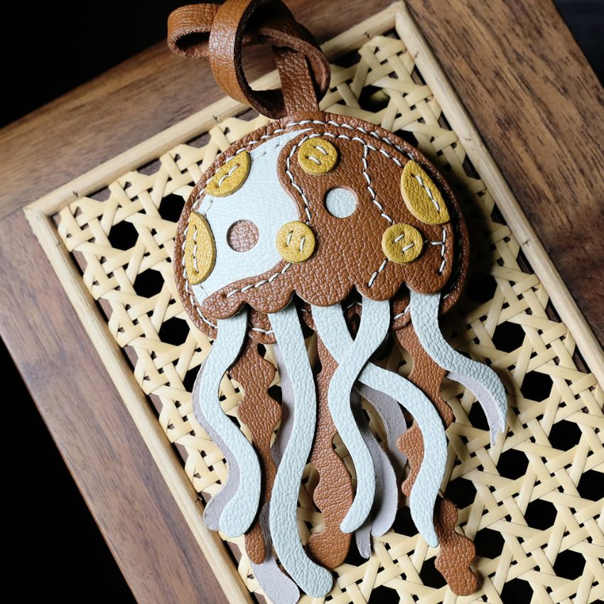 Sheepskin Leather Jellyfish Bag Charm Wholesale PU Leather Keychain Accessories displayed on canvas handbag as cute jellyfish keychain