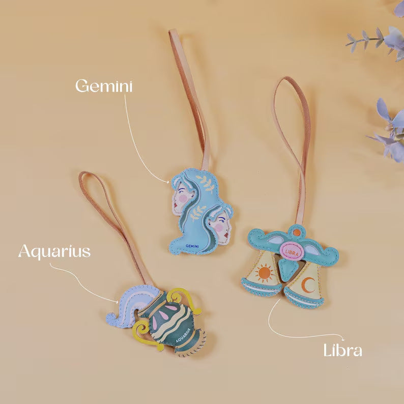 Zodiac bag charm wholesale handmade leather keychain accessories featuring Taurus Capricorn and Virgo signs displayed on handbag