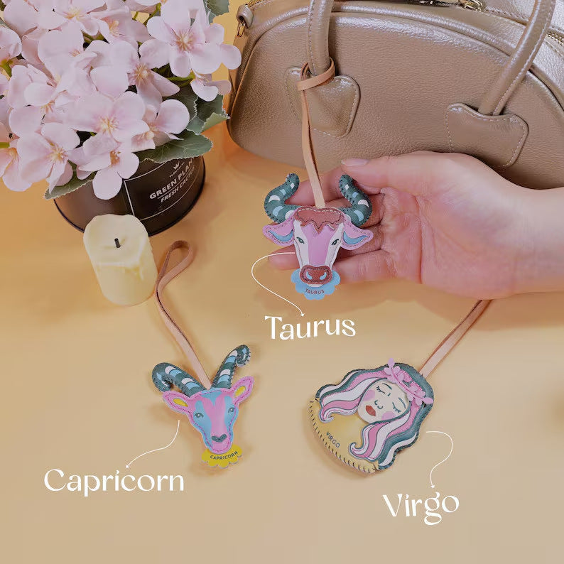 Cancer zodiac bag charm wholesale design displayed on brown leather handbag as handmade leather keychain accessory and unique gift for best friend woman