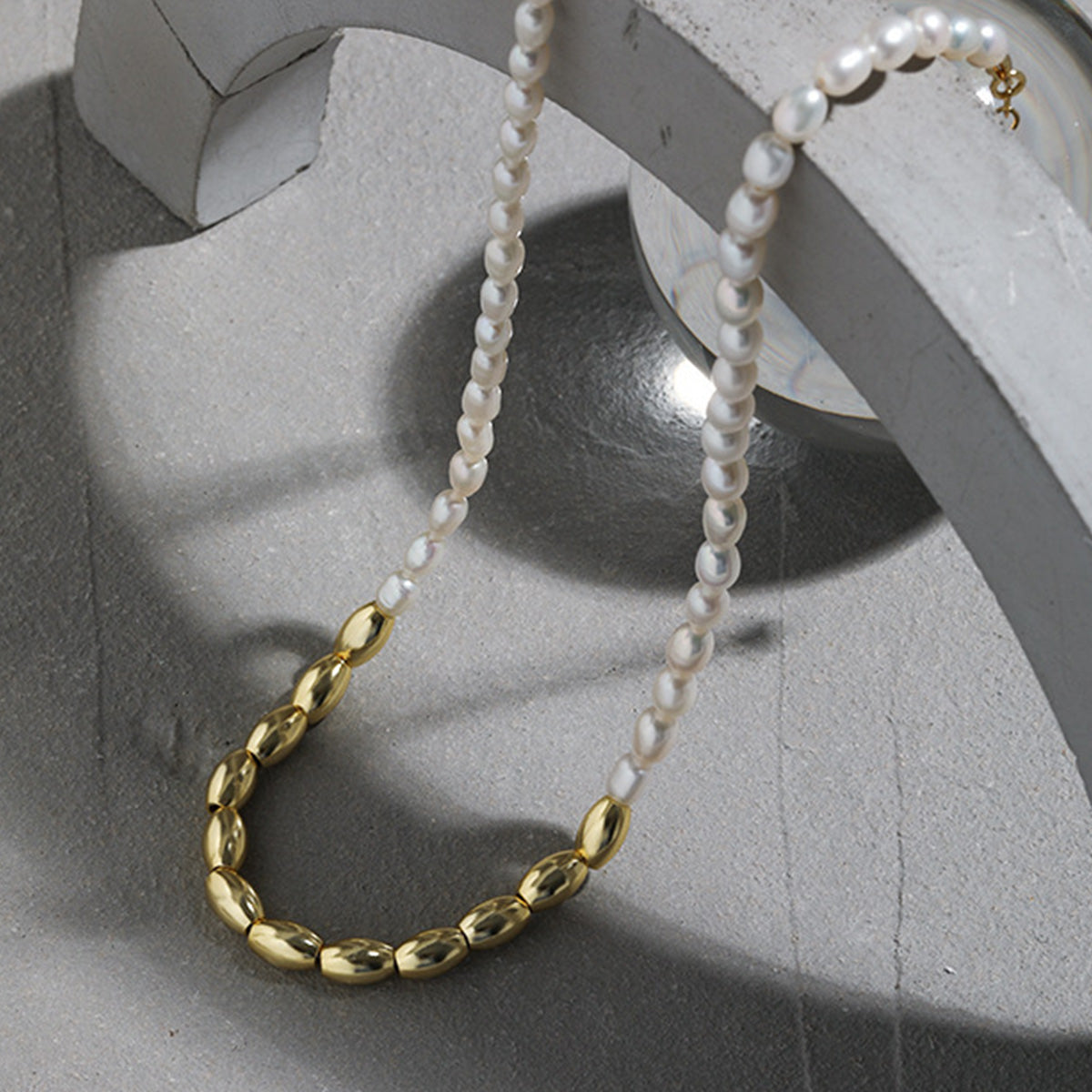 Model wearing a silver rice bead and freshwater pearl necklace in S925 sterling silver, versatile for wholesale and ins style fashion jewelry.