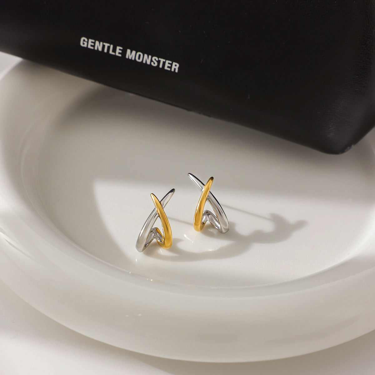 Gold and silver tone stainless steel crossed line earrings flat lay for wholesale display