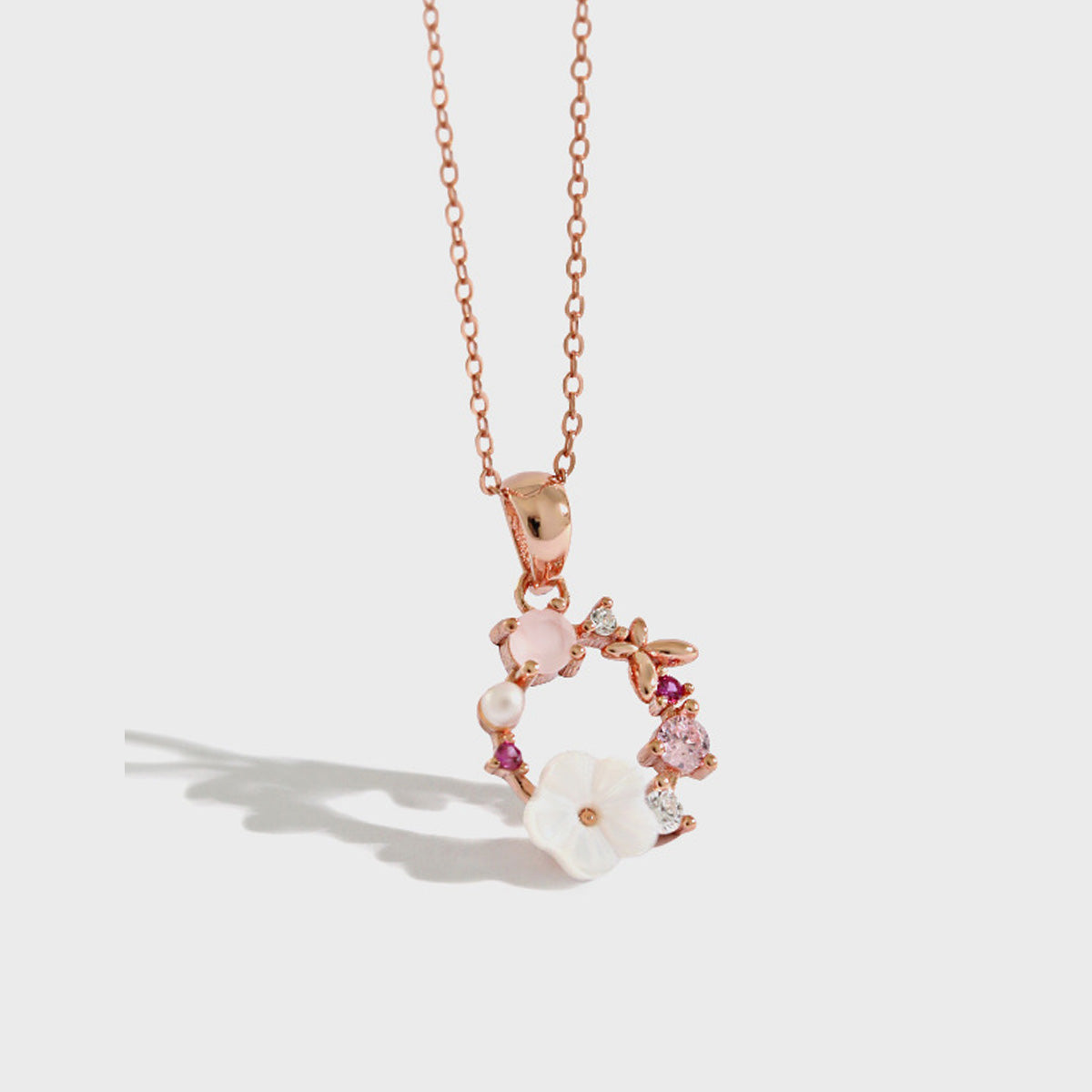 Rose gold floral wreath pendant necklace on white background, showcasing minimalist jewelry wholesale style and elegant pink tones for gifting