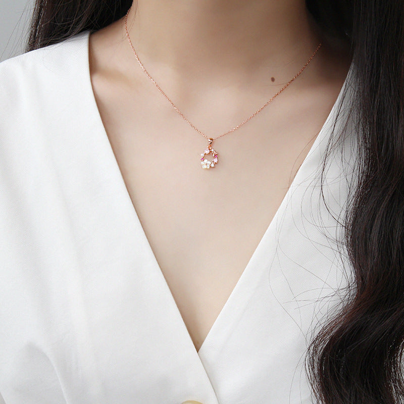 Delicate rose gold floral pendant necklace worn on model's neck, highlighting minimalist jewelry wholesale appeal and everyday wearability