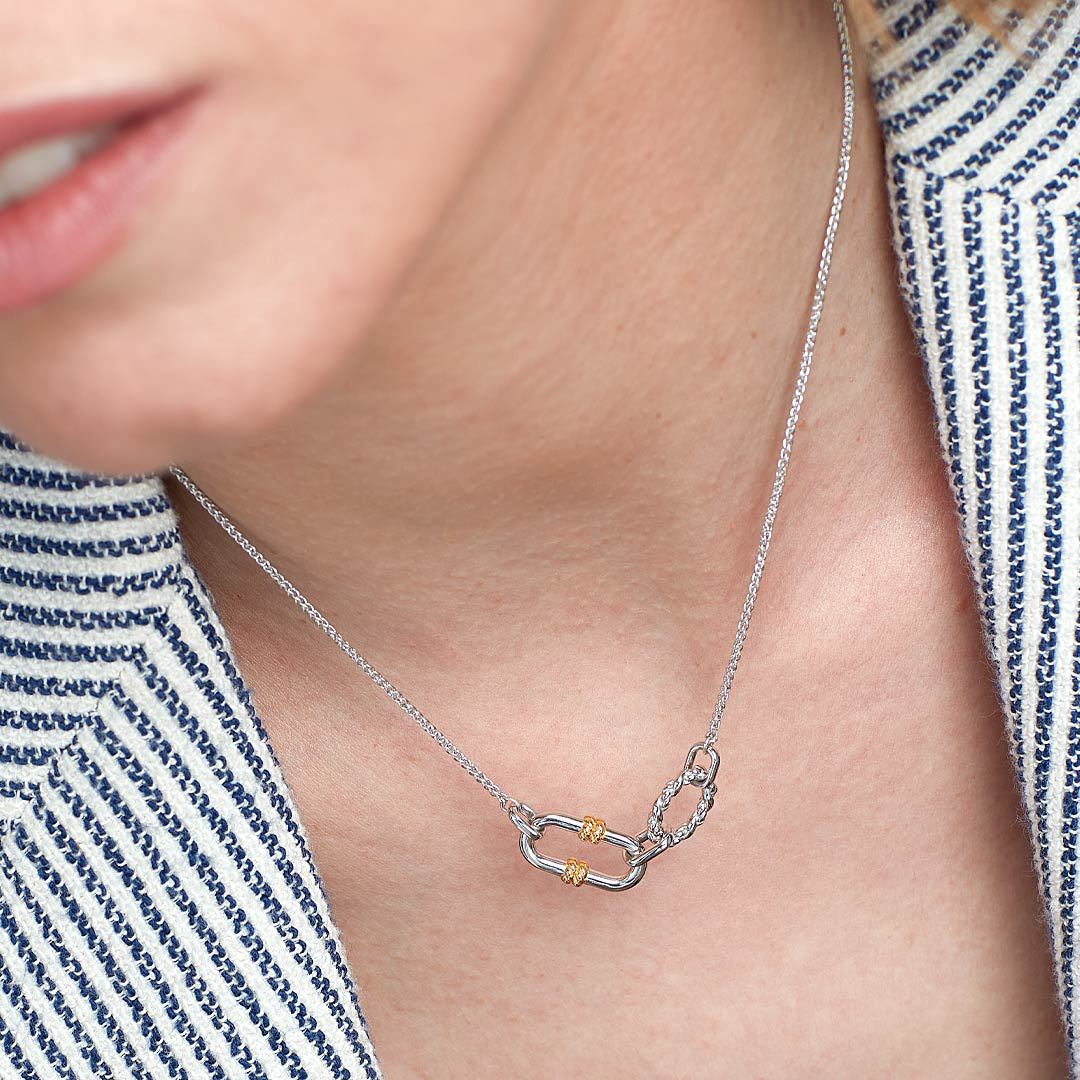 two tone knot pendant necklace worn on collarbone