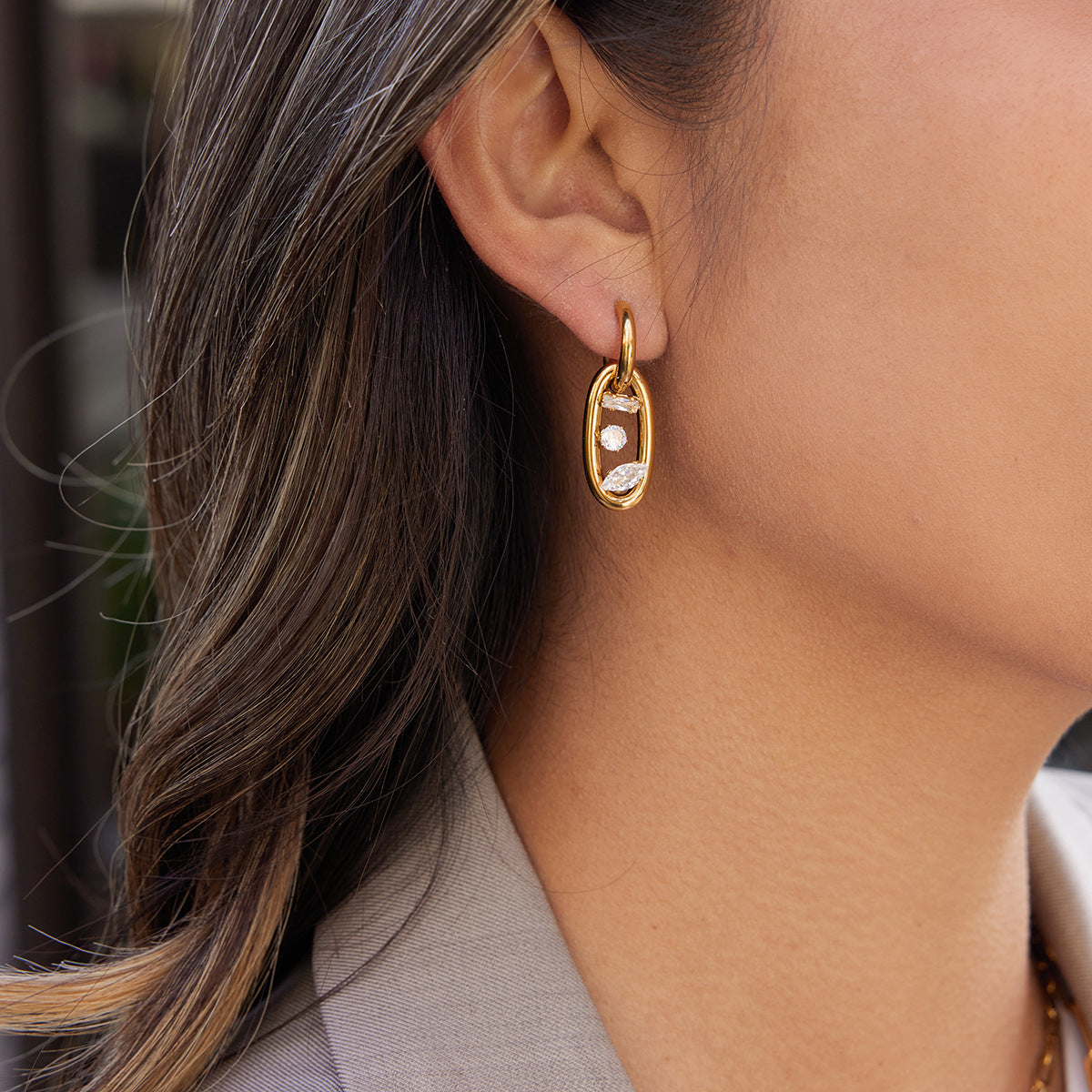 Model wearing gold tone geometric double hoop oval link zircon earrings