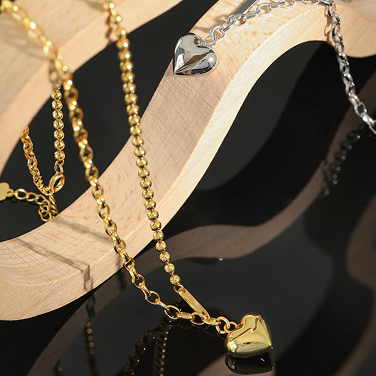 Gold and silver dual chain heart necklaces side by side, ideal for showcasing 925 silver jewelry for wholesale buyers.