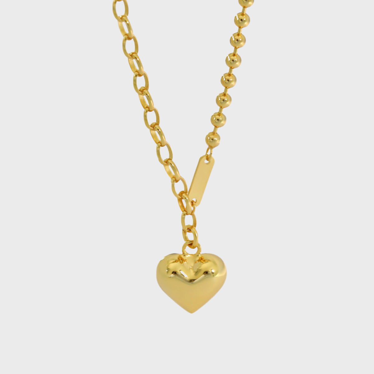 Close-up of gold heart pendant with dual chain design, perfect for minimalist jewelry wholesale and gift box sets.