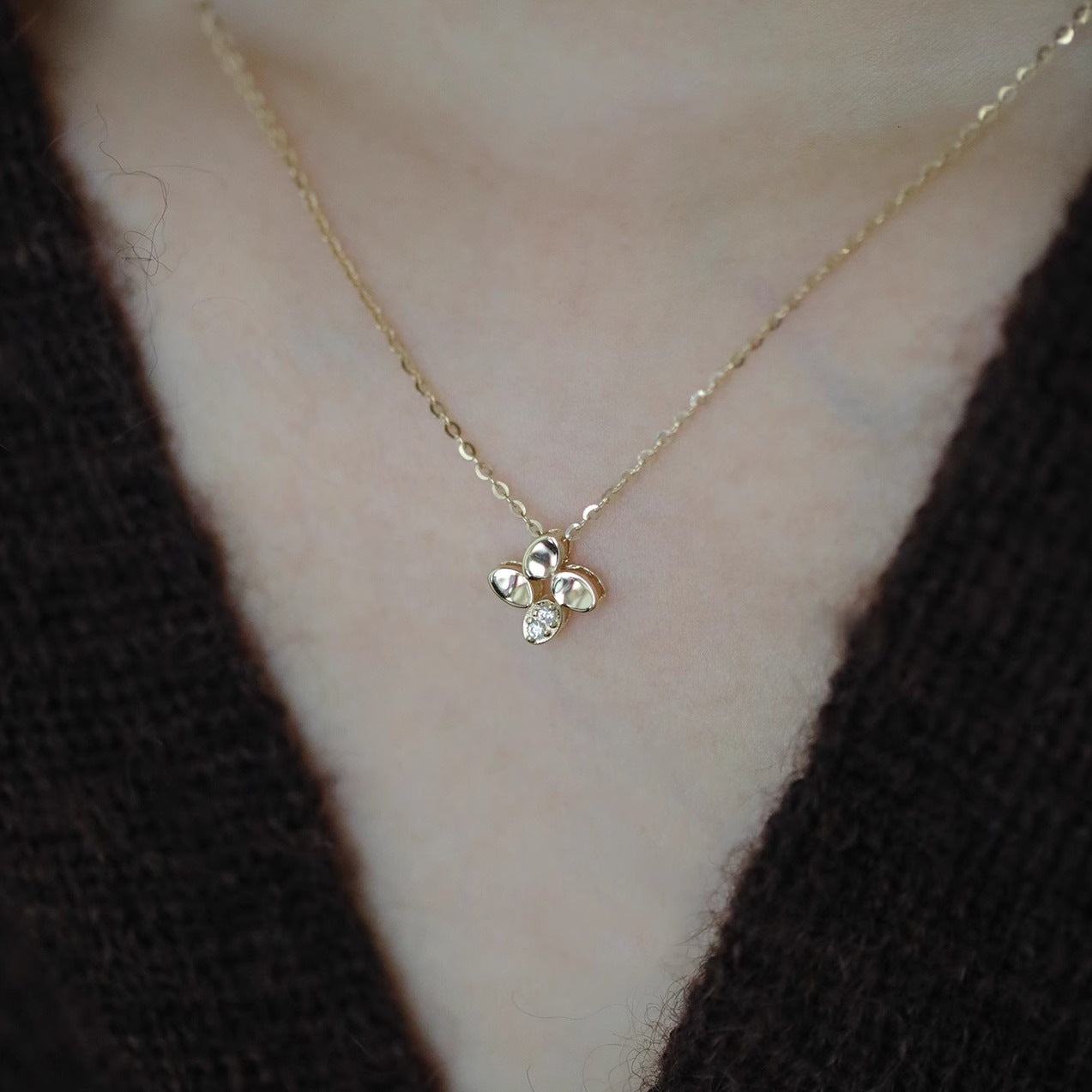 Model wearing lucky four leaf flower pendant necklace, 14K gold plated 925 sterling silver, wholesale jewelry set for boutiques.