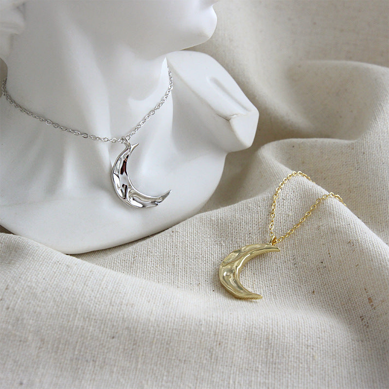 Close-up of gold hammered crescent pendant on chain, elegant and shiny design ideal for 925 silver jewelry bulk and wholesale.