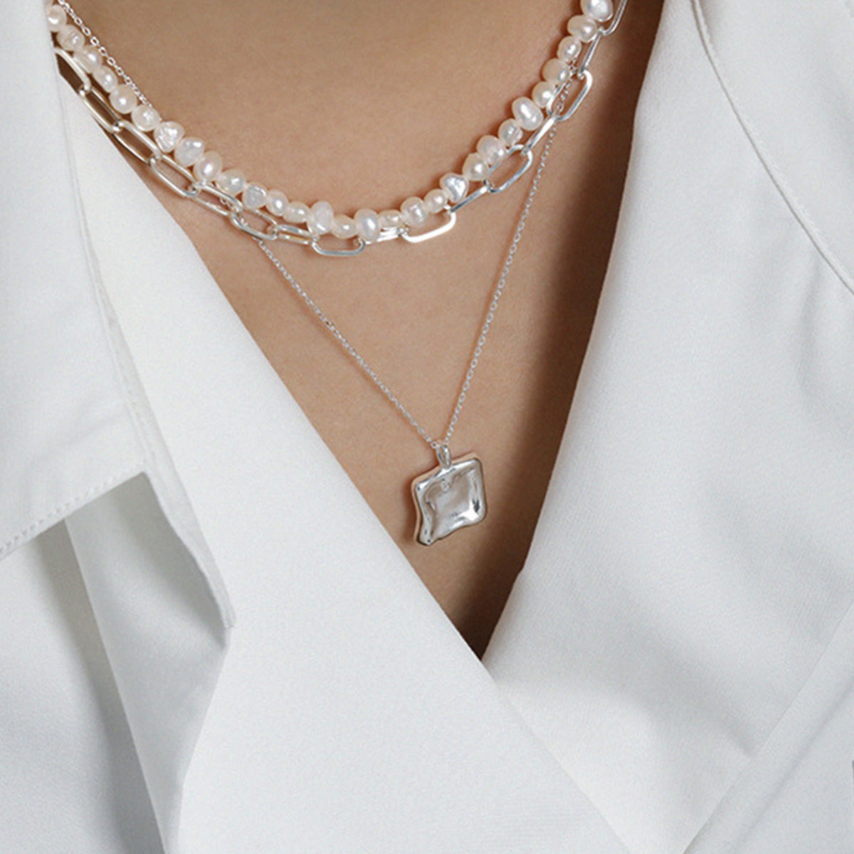 Silver square pendant necklace paired with pearl choker for minimalist jewelry wholesale