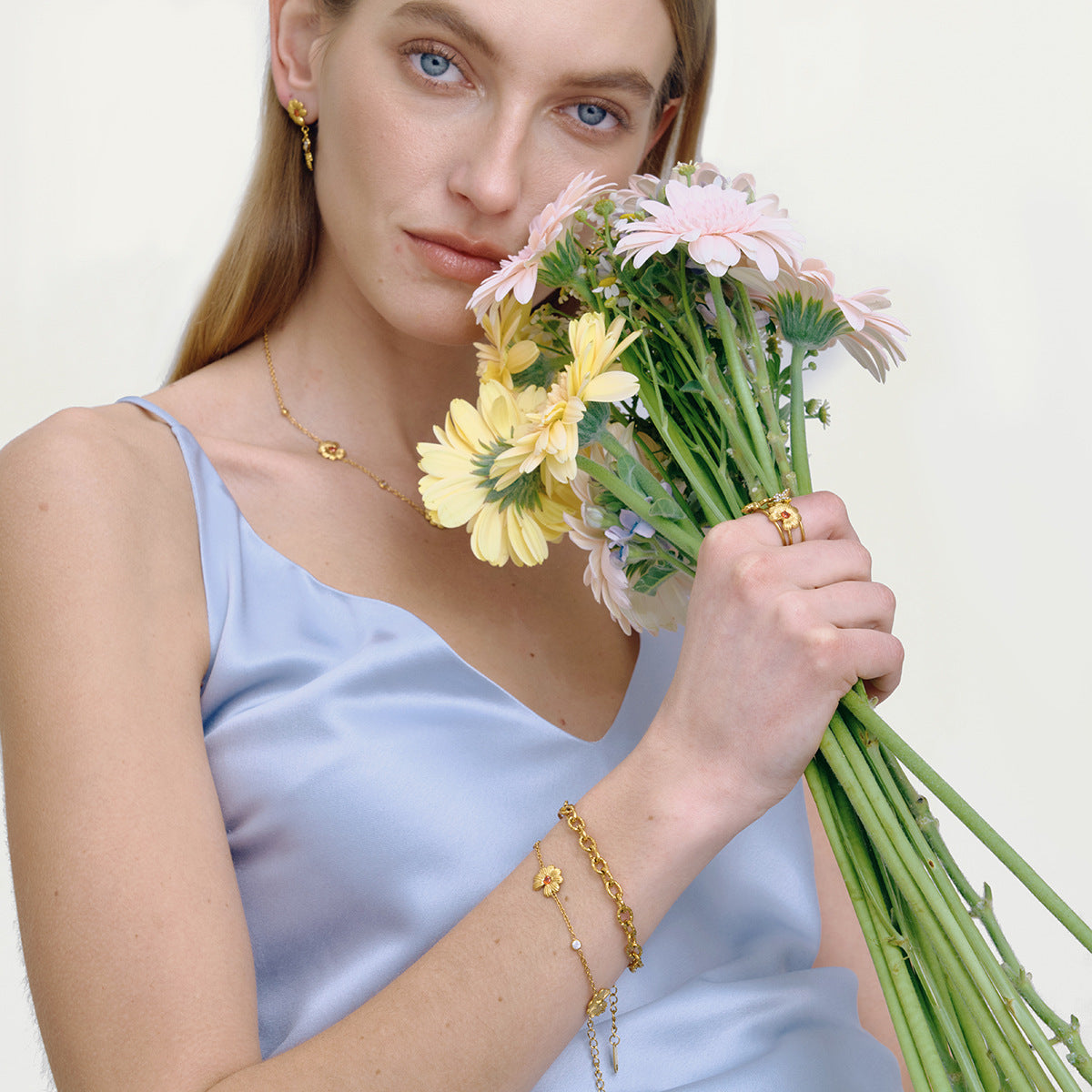model wearing gold daisy bee drop earrings with floral jewelry set