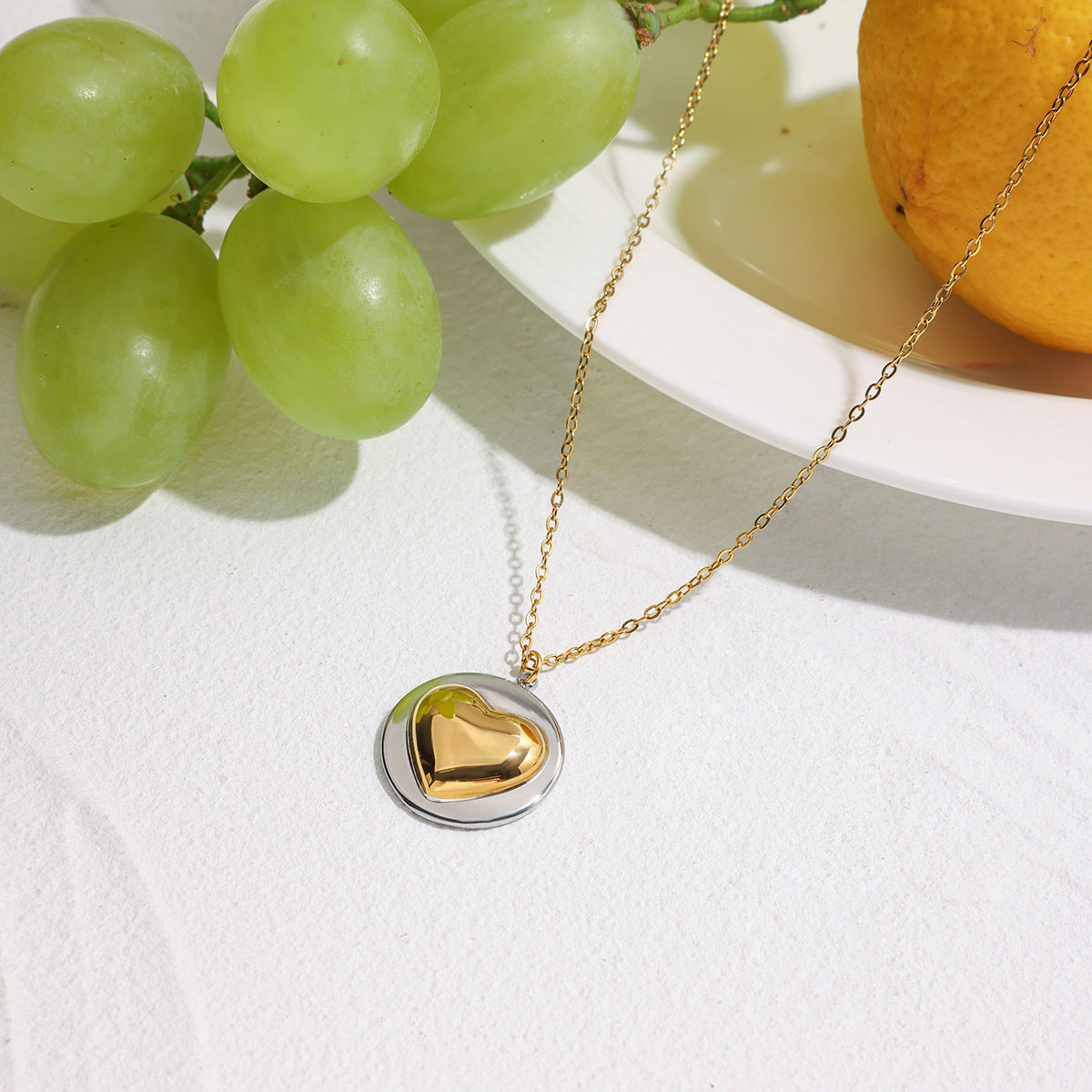 Model wearing wholesale stainless steel heart necklace layered with minimalist jewelry for women