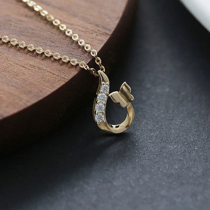 14K gold plated butterfly zircon pendant necklace displayed with gold chain on wood