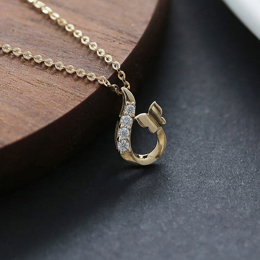 14K gold plated butterfly zircon pendant necklace displayed with gold chain on wood