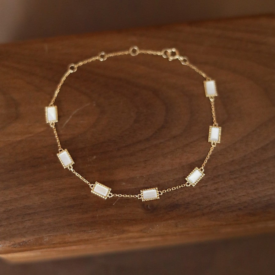 Close up view of 18k gold plated sterling silver mother of pearl bracelet on a vintage brown box for wholesale jewelry catalog