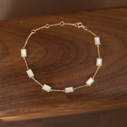 Close up view of 18k gold plated sterling silver mother of pearl bracelet on a vintage brown box for wholesale jewelry catalog