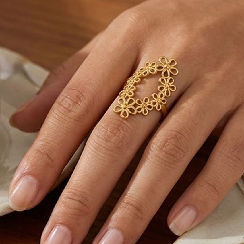 18K gold plated stainless steel floral statement ring worn with other gold rings