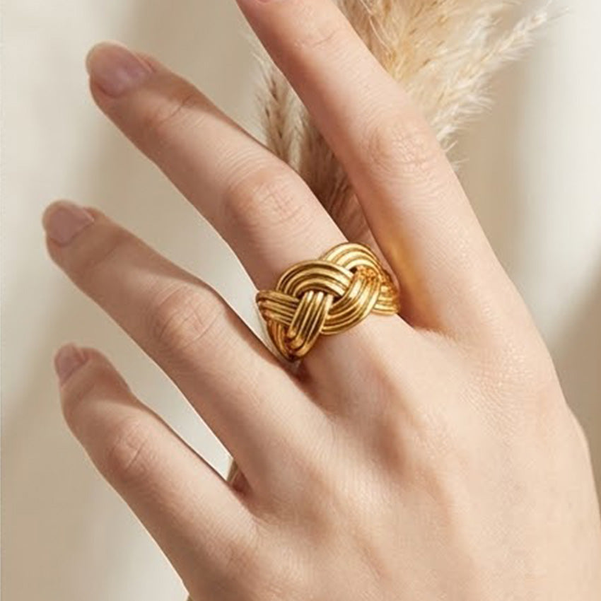 Gold tone woven knot statement ring worn on the finger
