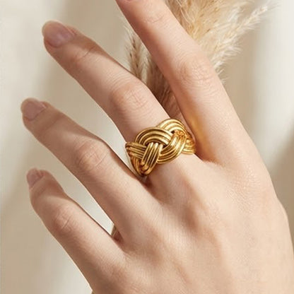 Gold tone woven knot statement ring worn on the finger
